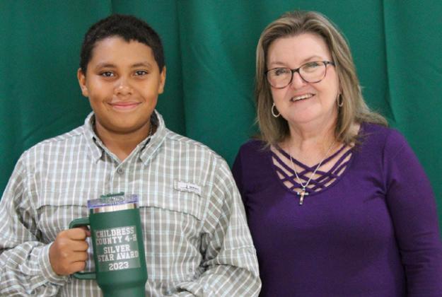 Quay Bruce receives the Bronze Star award from Childress County AgriLife Extension Service Secretary Ann Ricks. Bruce was involved in County Food Show, Beef Poster, Exhibit Board, Livestock Judging, Meat Judging, Photography, Record Book, Robotics, Penned Cattle, Lamb, County Horse Club Events and Entomology.