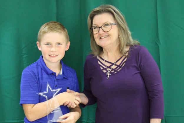 Kolt Whitaker receives Rookie of the Year from Childress County AgriLife Extension Service Secretary Ann Ricks. Whitaker was involved in 4-H Talent Show, County Food Show, Beef Poster, Exhibit Board, Photography, Record Book, Robotics, State Christmas Card Contest, Penned Cattle, Poultry, Archery and County Horse Club Events.