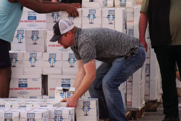 Community members, including local students, church youth groups, emergency responders, county and city officials and more, volunteer at the community water distribution, Monday, Feb. 28 in the Childress High School parking lot, following an over 30-hour citywide water outage due to a cracked mainline. The Red River Sun/Elizabeth Tanner