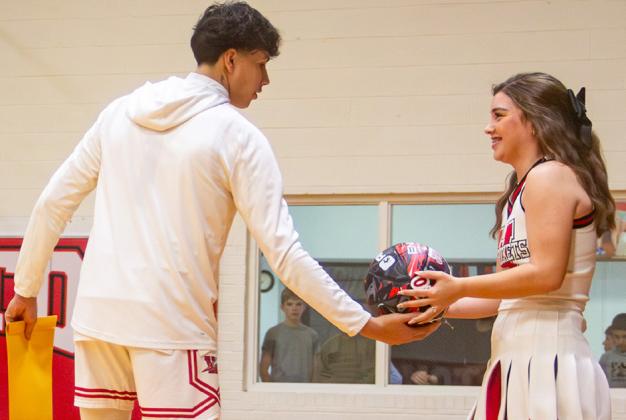 Senior cheerleader Treylea Wiebe accepts a basketball from classmate Tiny Hinojosa. The daughter of Henry and Amanda Wiebe, the teams expressed their appreciation to Treylea for cheering the Lady Rockets and Rockets to victory all these years.