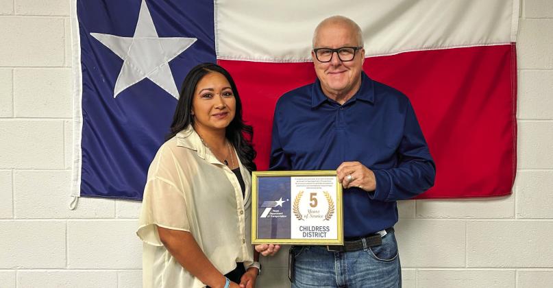 Texas Department of Transportation Childress District Engineer Darwin Lankford awards Construction Recordkeeper Tammie Lizama for five years of service.