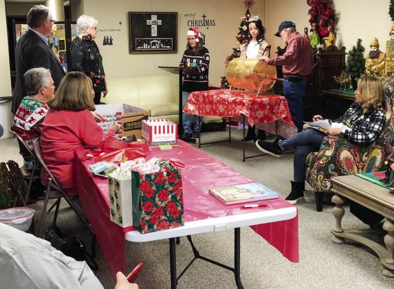 Citizens gather in the Ellis Art Center of the Collingsworth County Museum, amongst the Nativity and Wise Men exhibit, for the Christmas on the Bricks RED TICKET drawing at 5 p.m. Saturday, Dec. 17. Geney Gulley, left, Margret Wood, Neal Odom and Nancy Harris assist Karen Caldwell, Miss Wellington Summer Owens, Billy Wilkerson and Cecilia Orozco with the drawing and listen intently for names of the winners. The Red River Sun/Bev Odom
