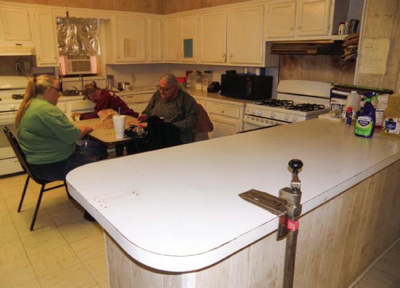 Kitchen improvements at the Childress Senior Citizens Center include the replacement of cabinetry, including the foreground island, due to deterioration and water leakage. At the table, “picking beans” for Tuesday’s luncheon, are, from left, Connie Grayson and Connie Ferrill.