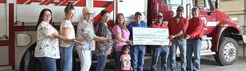 From left: Chamber President Cindy Weatherly, Chamber Treasurer Cameron Warren, Chamber Volunteers Nancy Harris and Margret Wood, Chamber Vice President Cari-Ann Wynn with Charlotte, Chamber Volunteer Billy Wilkerson, Wellington VFD Treasurer Ethan Cummings, Fireman Korn Wiebe, and Training Officer and Secretary Matt Wynn.