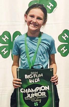 Raylie Sims displays her first-place individual award in the Junior Consumer Decision Making contest. Her team, including Berkeley Ward and Peyton Roberson, received third place.