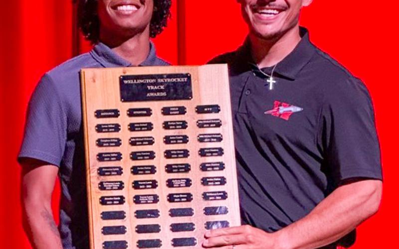 Wellington High School Junior Troy Molina accepts the Boys’ Track Sprinter Award, presented by Coach Jared Casas.