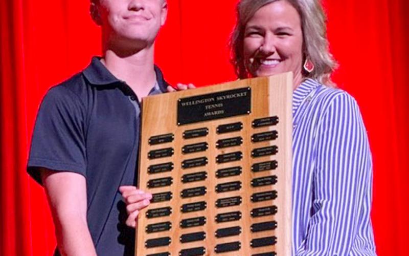 Wellington High School Sophomore Jax Heflin accepts the Tennis Most Improved Boy Award, presented by Coach Amy Inman.
