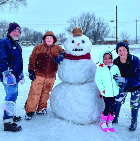 The Granados family creates a life-size snowman during the Tuesday, Jan. 24 snow day in Wellington. The six-to-eight inches of wet snow lingered in shady spots across Collingsworth County into this week, coupling with the subfreezing temperatures. From left: Rafael Granados, Alex Garcia, Aliviah McGrady and Maria Granados. Courtesy Photo