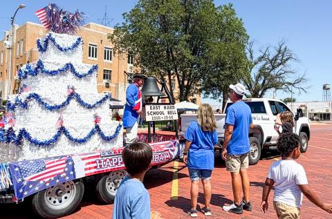 Only a small crowd gathers as Danny Sain, portraying an Early American Patriot Soldier on Collingsworth County Museum’s float, rings the former East Ward School bell at noon Saturday, July 4 in front of the Collingsworth County Courthouse following Wellington’s “Red, White and Boots” parade. Sain rang the bell 25 times, with each ring commemorating 10 years of America’s “let freedom ring” history. BEV ODOM/THE GREENBELT INTREPID