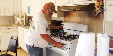 James Votaw checks the range at the Childress Senior Citizens Center following a report of a possible gas leak. The smell of gas recently occurred with the range as the possible source, Childress Senior Citizens Center Director Glenda Goundie said. Photo by Grace Holman