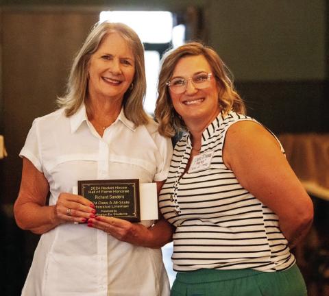 Kathy Sanders accepts the 2024 Rocket House Hall of Fame distinction in honor of her late husband, Richard Sanders, presented by Lana Tillman, a member of the Wellington Ex-Student Association Board of Directors Nicole Yarborough Photography