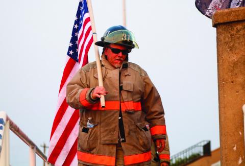 Childress Fire Department firefighter Jimmy Willis carries an American flag during the 9/11 Memorial Stair Climb event in 2021. The Red River Sun/Nicole Dill