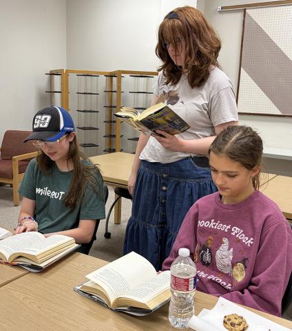 Wellington students Natalee Hudson, left, Rosalind Stiles, and Trinity Tulley preview potential titles for the first book club offered for grades 8-12 last Thursday, Sept. 10. The new organization plans to meet from 5:30-6:30 p.m. the second, fourth and fifth Thursday of each month. INTREPID PHOTO / BEV ODOM
