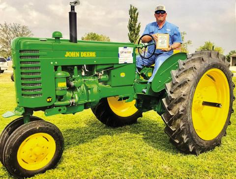 Kenneth Ellis’ classic John Deere tractor, shown by Chance Taylor, brings home the Founders Memorial Award at the recent 21st Annual Panhandle Antique Tractor Association Show and Raffle at High Plains Children’s Home and Family Services in Amarillo. Courtesy Photo