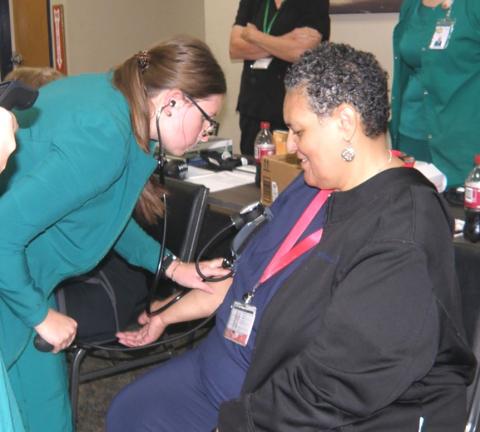 Sylvia Douglas of Clarendon College does a blood pressure reading for Kady Belle McKee at the CRMC/ Childress County Extension Service Health Fair. A blood sugar level test also was administered, with McKee given a log to maintain before seeing her personal physician. INTREPID PHOTO / GRACE HOLMAN