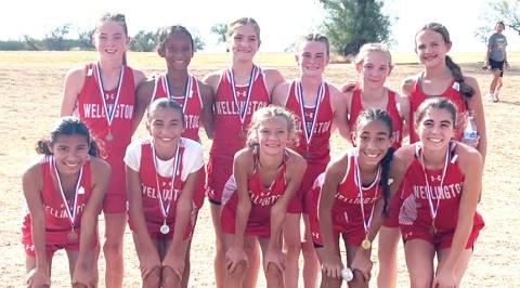 The Wellington Junior High School Lady Firecrackers, including front, Kesley Hamner, Mariah Medina, Calleigh Henard, Aryen Garcia, Quinn Roberson, and back, Kenlea Martin, Jadah Casas, Evey Henard, Taytum Martin, Veva Finnegan, and Berkley Ward, earned the Junior High District 2-2A cross country title on Tuesday afternoon, Oct. 13, at Quanah Country Club. WELLINGTON JUNIOR HIGH SCHOOL