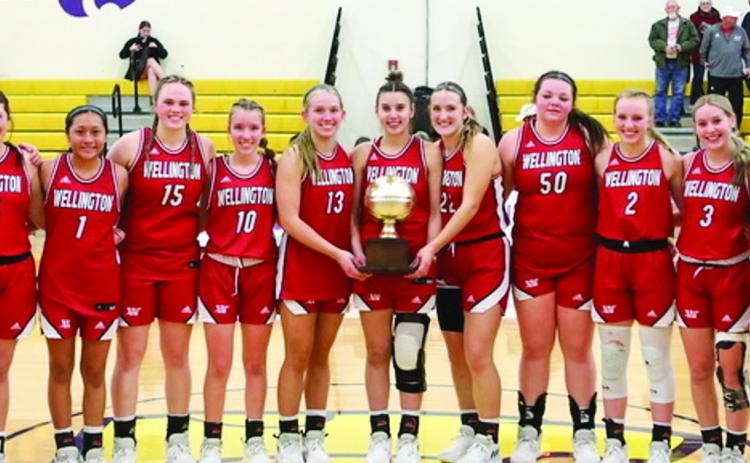 The Wellington Lady Rockets accept the bi-district championship trophy Monday, Feb. 13 at River Road High School in Amarillo. From left: Kaesyn Kane, Ava Kate Inman, Coach Skyler Warrick, Brynlee Proffitt, Leslie Orozco, Briley Waters, Brynlee Phillips, Kaitlin Bawcom, Charley Wilbur, Audrey Jones, Kali Brewer, Presley Kane, Harlee Gomez, Asia Shrubs, Abby Garcia, Coach Cade Brown. Lukas Wilbur Photography