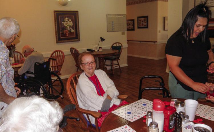 Linda Rothwell has her bingo cards ready for the next game at the weekly bingo session at Cottage Village Assisted Living Facility in Childress. At left, in the foreground, is Frances Weatherlee and Ann Simmers, a regular bingo-time visitor. At right is Cottage Village Caregiver Kimberly Ramos. The number of weekly games played depends on how many the residents request, said number caller Anne Fromm.