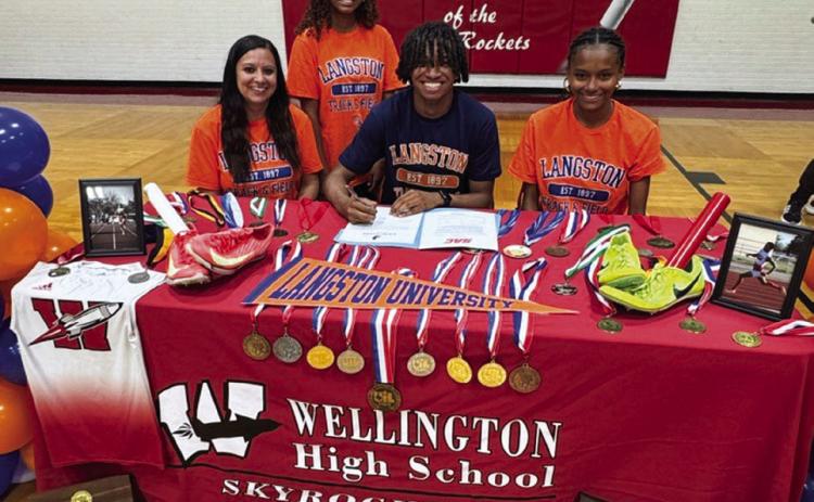 Wellington High School senior DeMarcus Lewis signs a National Letter of Intent to run track at Langston University, located in Oklahoma. From left: his mom, Angela Lewis; sister Aleah Lewis; Lewis; sister Angela Lewis. Wellington High School
