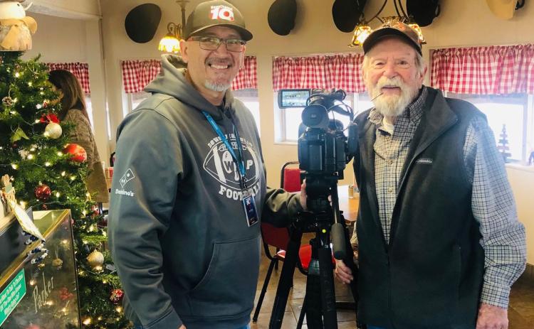 Amarillo NewsChannel 10’s video journalist Ruben Flores makes a stop at Two Rivers Family Restaurant on Highway 83 in Wellington Tuesday morning, Jan. 2. Collingsworth County Chamber of Commerce volunteer Billy Wilkerson welcomes Flores for his “Ruben on The Road” feature story concerning the hats that line the dining room wall. The Red River Sun/Bev Odom
