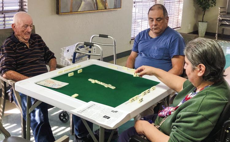 From time-to-time, 97-year-old Harry Stallings, left, still instigates an entertaining game of dominoes with residents of Wellington Care Center. When not playing dominos, Stallings can sometimes be found fishing. The Red River Sun/Bev Odom