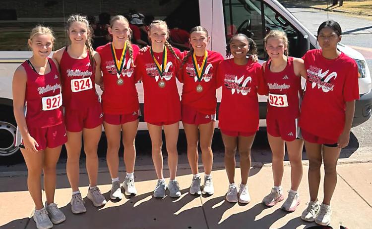 The Wellington Lady Rocket cross country team, including Ava Kate Inman, Anna Henard, Kaesyn Kane, Taytum Kane, Claire Kane, Aleah Lewis, Halle Hedrick, and Priscilla Marentes, garners second place at Guthrie’s Rattlesnake run on Wednesday, Sept. 9. WELLINGTON HIGH SCHOOL