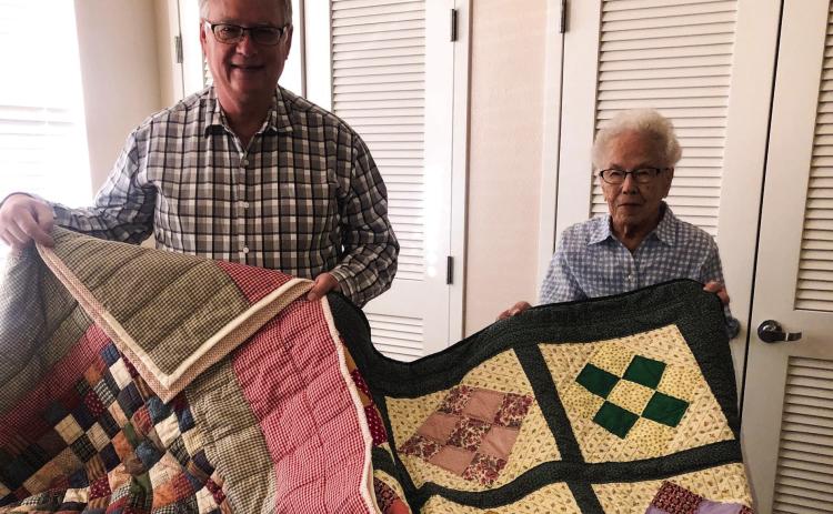 Neal Odom assists Odessa Covey in displaying two quilts, made by Covey, which will be auctioned during the Wellington Methodist Women’s Fall Bazaar at 12:30 p.m. Saturday, Nov. 5. The Red River Sun/Bev Odom