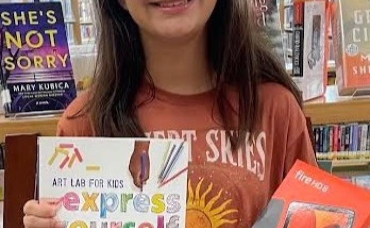Wellington Junior High School eighth-grader Emma Zaragoza claims the teen Summer Reading Program prize, a brand-new Kindle Fire HD 8, to promote her love of reading even more.