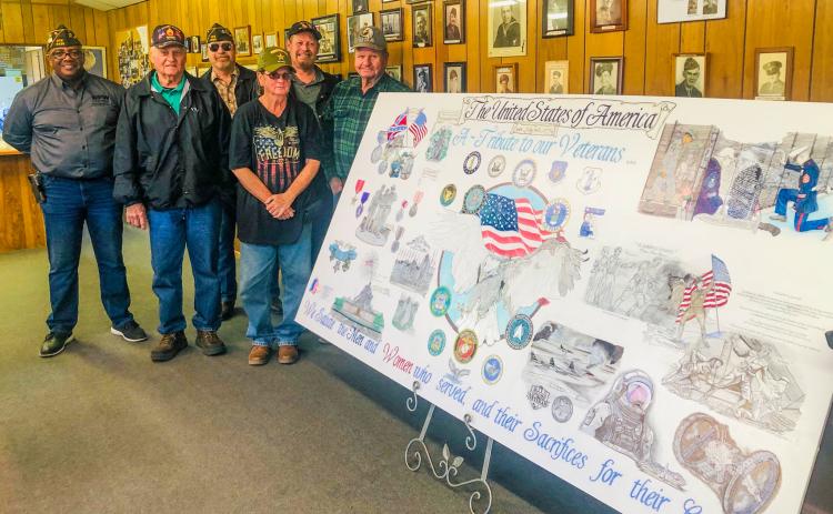 Alesia “Lisa” Freeland, a veteran of the U.S. Army, displays her four-foot-by-eight-foot mural designed to honor all the branches of the military, in all conflicts, from the Revolution to the Space Age. Freeland displayed her artwork at the recent Veterans Day lunch at the Glynn Moore Veterans of Foreign Wars Post 6439, the new home of “A Veteran’s Tribute.”