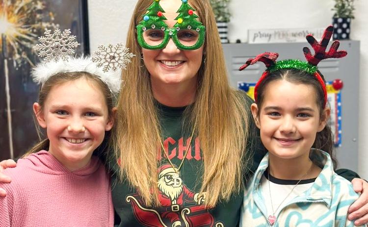 Wellington Elementary School Principal Deidre Kane gathers with fifth-graders Raylie Sims, left, and Summer Valles on Thursday, Dec. 18 for “Holiday Headgear… Spread the Cheer!” prior to the Friday, Dec. 19 release for the Christmas holiday. Teachers return to work Monday, Jan. 5, while students return Tuesday, Jan. 6.