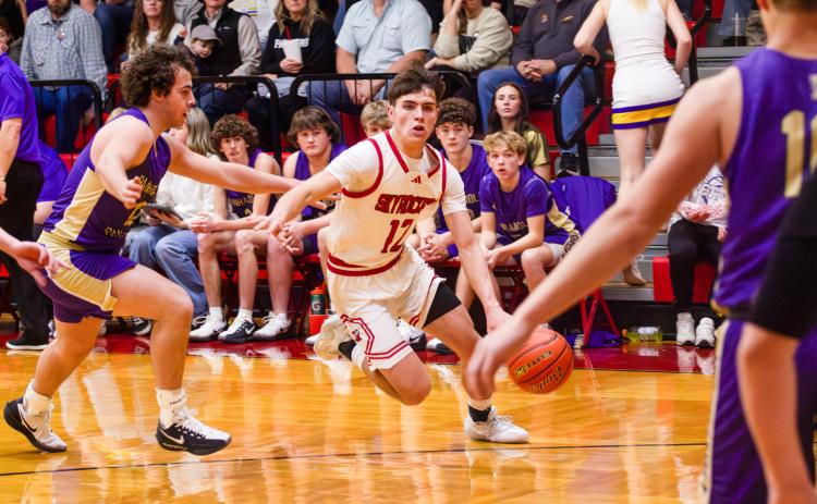 Wellington’s Jax Cantu evaluates opportunity, while Carson Kane (10) and Easton Wischkaemper (13) move into play position last Friday, Feb. 6 against Wheeler, securing a 68-51 win.