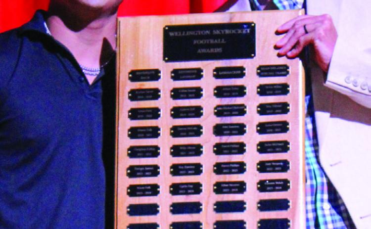 Wellington High School (WHS) senior Miguel Rincon accepts the Football Defensive Linebacker Award, presented by Athletic Director Greg Proffitt, at WHS’s Academic and All-Sports Banquet at 5:30 p.m. Monday, May 12 in the WHS auditorium. The Red River Sun/Shauna Salinas