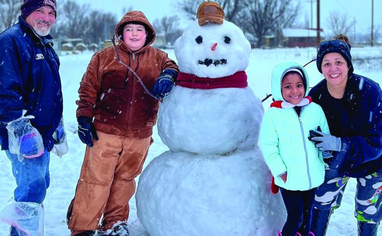The Granados family creates a life-size snowman during the Tuesday, Jan. 24 snow day in Wellington. The six-to-eight inches of wet snow lingered in shady spots across Collingsworth County into this week, coupling with the subfreezing temperatures. From left: Rafael Granados, Alex Garcia, Aliviah McGrady and Maria Granados. Courtesy Photo
