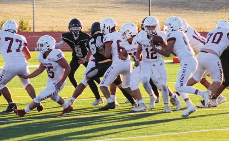 Junior varsity Skyrocket Lawson Inman (12) hands the ball off to Alex Orozco (5) in the game last Thursday, Halloween night, Oct. 31, in Canyon, where Wellington manhandled 4A Randall, taking a 24-12 win. Rockets Christopher Reyes (77), Dakota Ledbetter (55), Jr. Vega (50), Aison Skelton (70) and Jake Chandler (10) clear the way for Orozco. The Red River Sun/Shauna Salinas
