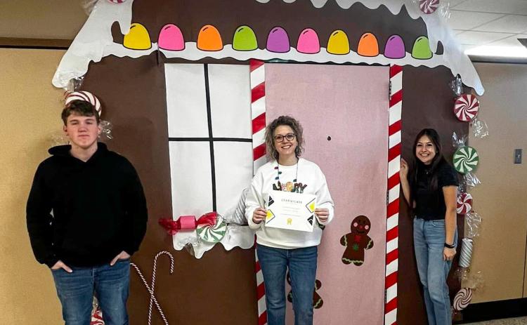 Memphis High School Family, Career and Community Leaders of America (FCCLA) Adviser Summer Lindley accepts first place in the holiday door decorating contest, thanks to her rendition of a gingerbread house. Photos Courtesy of Memphis ISD