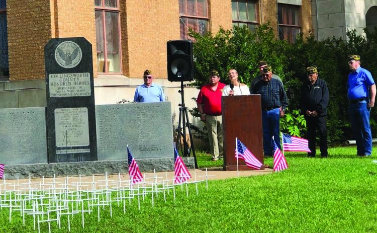 Wellington High School senior Madeleine Kane performs the National Anthem during the Memorial Day service at the Collingsworth County Honored Heroes Veterans Memorial. Officers of Glynn Moore Veterans of Foreign Wars Post 6439 Tony Stephens, left, Benito Castillo, Jr. Castillo, Michael Stanley, Adam Sosa, Jeff Pastor and John O’Rear conducted the ceremony. The Red River Sun/Bev Odom