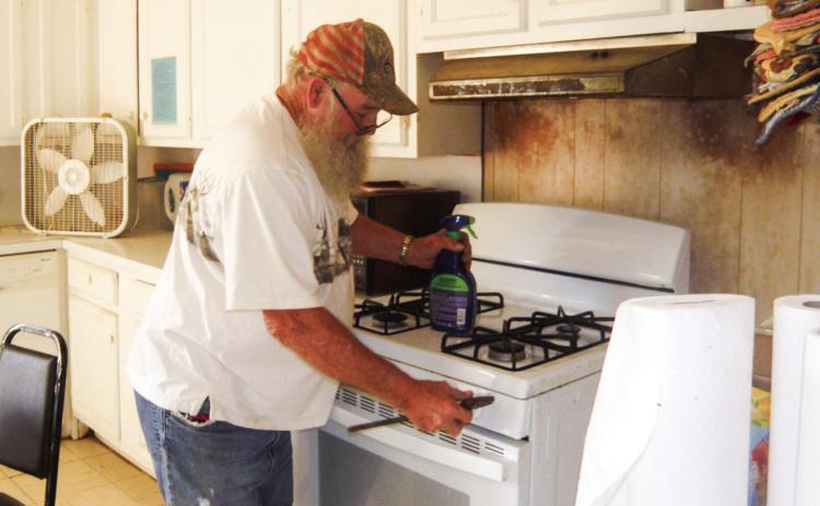 James Votaw checks the range at the Childress Senior Citizens Center following a report of a possible gas leak. The smell of gas recently occurred with the range as the possible source, Childress Senior Citizens Center Director Glenda Goundie said. Photo by Grace Holman