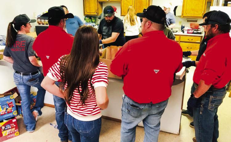 Wellington volunteer firemen, family members and Brothers-Sisters of our Military (B.O.O.M.) Adventures volunteers assemble brisket sandwich meal sacks for the Salinas family fundraiser Sunday, March 2. From left: Marcie Orr, Jonathan Hamby, Larry Valles, Brylnn Kemp, Joe Carrol, Molly Sims, Makenzie Smith, Whitney Wiebe, Chance Byers, Teresa Valles, Benny Wiebe, Henry Wiebe. The Red River Sun/Bev Odom
