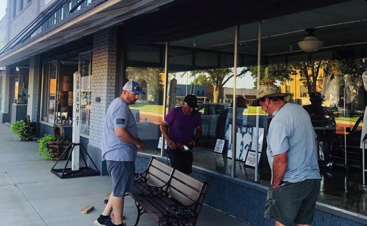 Wellington Community Fund board members Justin Mixon, left, Jimmy Cantu and Charlie Taylor install park benches Monday, June 24 on the Collingsworth County Courthouse Square. Not only a beautification project, the eight benches provide a place for rest and relaxation. Photo Courtesy of Karen Caldwell