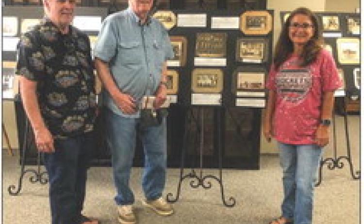 Scott Clark, left, and his dad, John Clark, a member of the Wellington High School Class of 1949, view Collingsworth County Museums “Once Upon Our Past” snapshot exhibit, which begins in 1898. Collingsworth County Museum Assistant Director Karen Caldwell welcomes the Clarks, both of Dewey, Ariz. Since 2019, the duo has enjoyed traveling back to Wellington to watch a Skyrocket football game. The Red River Sun/Bev Odom