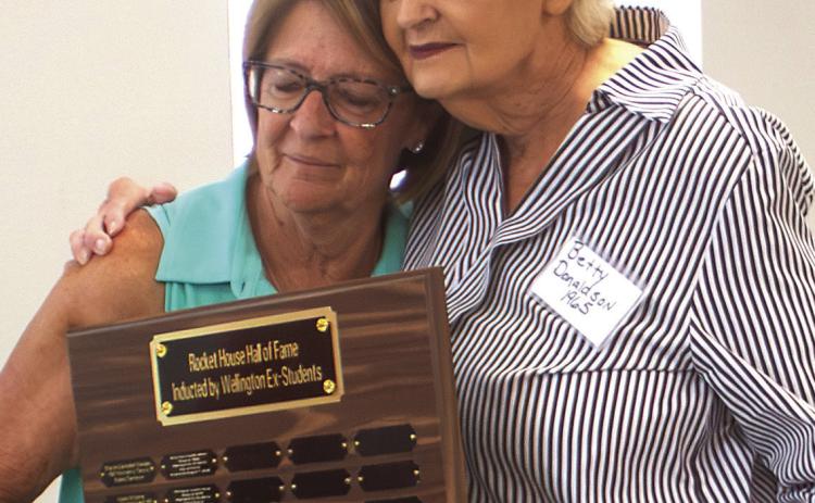 Betty Courtney Donaldson, Wellington High School Class of 1965, embraces Renee Hanna as she is named a 2026 Rocket House Hall of Fame inductee. HZW MEDIA PHOTO