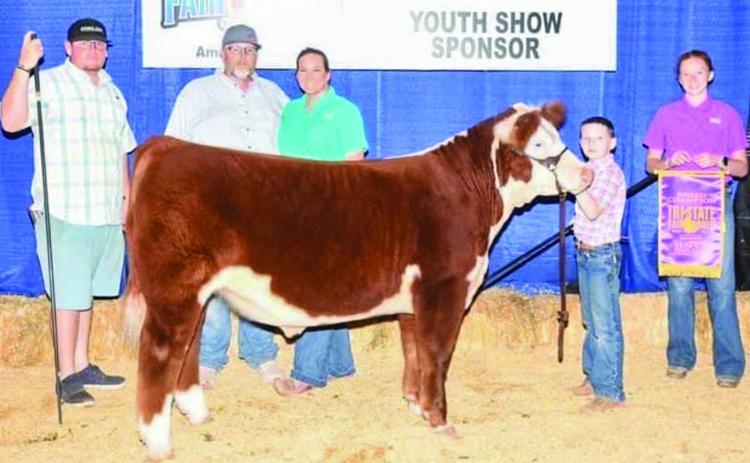 Jacob Page, a third grader at Wellington Elementary School, exhibits the Hereford Breed Champion with his steer, Hank, at the recent Tri-State Fair and Rodeo in Amarillo. From left: Trevor Rosso, Jeremy Page, Katie Page, Jacob Page, Bailey Page. Courtesy Photos