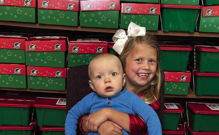 Lennox and Kellyn Conner, children of Tucker and Jordan Conner, complement the 117 Christmas shoeboxes, assembled by First Baptist Church Wellington, for Samaritan’s Purse Operation Christmas Child to be shipped to children in need around the world. The Red River Sun/Bev Odom