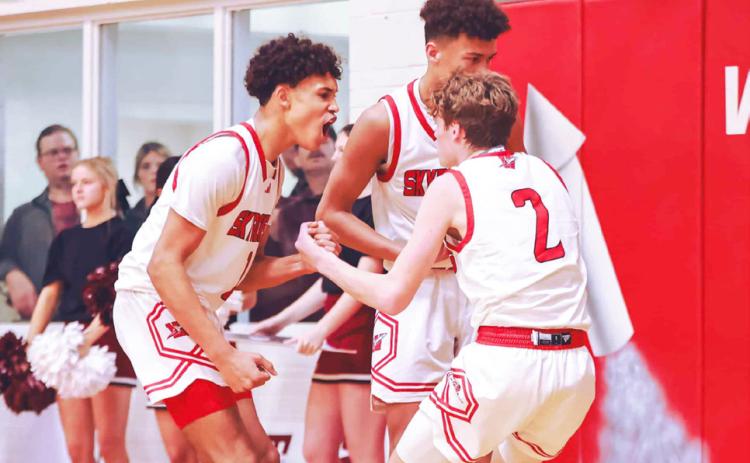 Wellington’s Brenden Garcia, left, celebrates with teammates after making a big play against Clarendon during a District 2-2A game Friday, Jan. 19. Press Pass Sports/James Abel