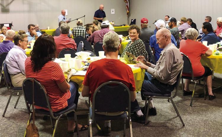 Tri-County Cooperative Enterprises, Inc. President Rex Henard turns the program back over to Manager Jeff Camp following the election of new directors during the recent annual meeting event. The Red River Sun/Bev Odom