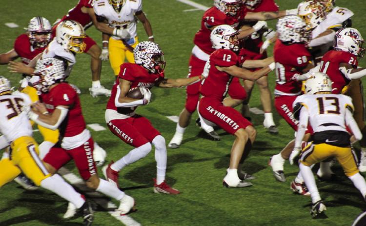 Wellington’s Brenden Garcia (1) runs the ball behind his blocks, Callen Kane (12), RJ Granadoz (60), Noah Cantu (4), Travon Lewis (21), Dalton Holland (73) and Anthony Ortiz (15), as the Skyrockets closed the season in a 24-13 final against the Collinsville Pirates Friday, Nov. 22 in Iowa Park. The Red River Sun/Shauna Salinas
