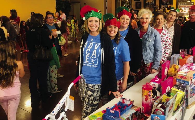 Court Appointed Special Advocates (CASA) of the Rolling Plains Executive Director Connie Monzingo, left, Volunteer Coordinator Nicole Brooks and Program Director Jamie Hall gather with Ritz Theatre Board President Lyndy Forrester-Black and Ritz Board Members Amy Inman, Tracey Ouellette and Eddie Langford for a Merry and Bright PJ Dance Party Thursday, Dec. 8. With admission being a $5 toy per family, gifts benefit children served by CASA of the Rollings Plains. The Red River Sun/Bev Odom