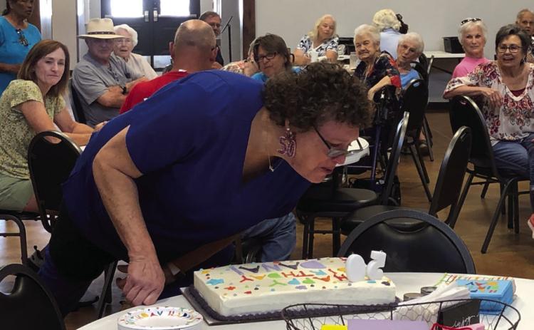 Decked out in her “50” earrings, Dana Langford Hughs blows out her candles at a surprise birthday party in her honor at 12:30 p.m. Monday, July 17 at Wellington Senior Citizens Center, where Hughs serves as kitchen manager. The Red River Sun/Bev Odom