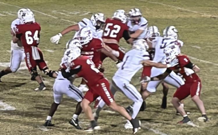 Skyrocket quarterback Cal Kane (12) gains ground against the Clarendon Broncos last Friday night at Powell Field while Gunner Guy (64), Cix Killian (21), Hunter Hedrick (52), Conner Bowen (2) and other Rockets block for Kane. Wellington (6-1, 2-0) sealed the 46-6 win. INTREPID PHOTO / BEV ODOM