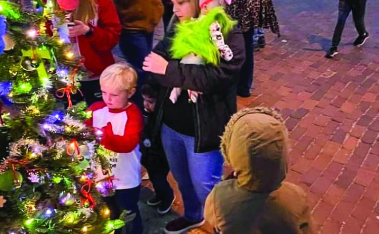 Visitors pause at Gigi Waller’s “Blessing Tree” to attach a hand-written memory or prayer during the 2021 Lighting of the Square events on the Collingsworth County Courthouse Square. Look for Waller’s 2022 “Blessing Tree” on the grounds of the courthouse. Courtesy Photo